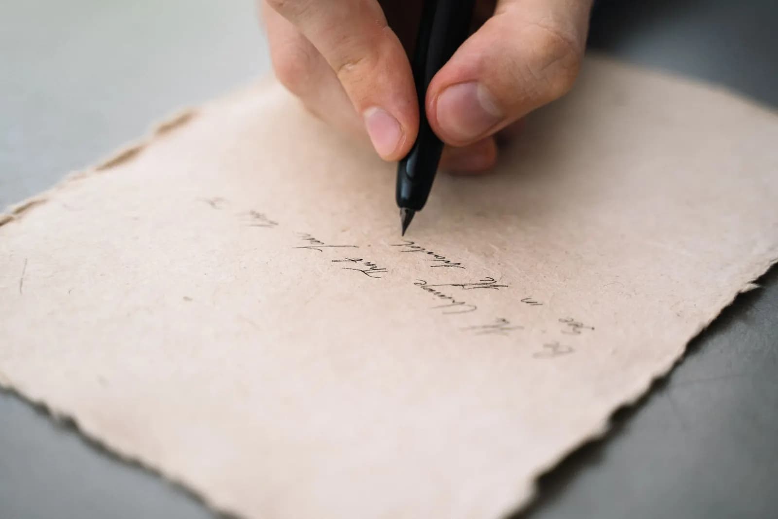 Eine Hand schreibt mit einem Stift auf Papier